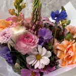 Close up image of Florada floral bunch with mixed flowers as selected by florist including dahlias, ranunculus, lupins, cornflower, cosmos and carnations. 