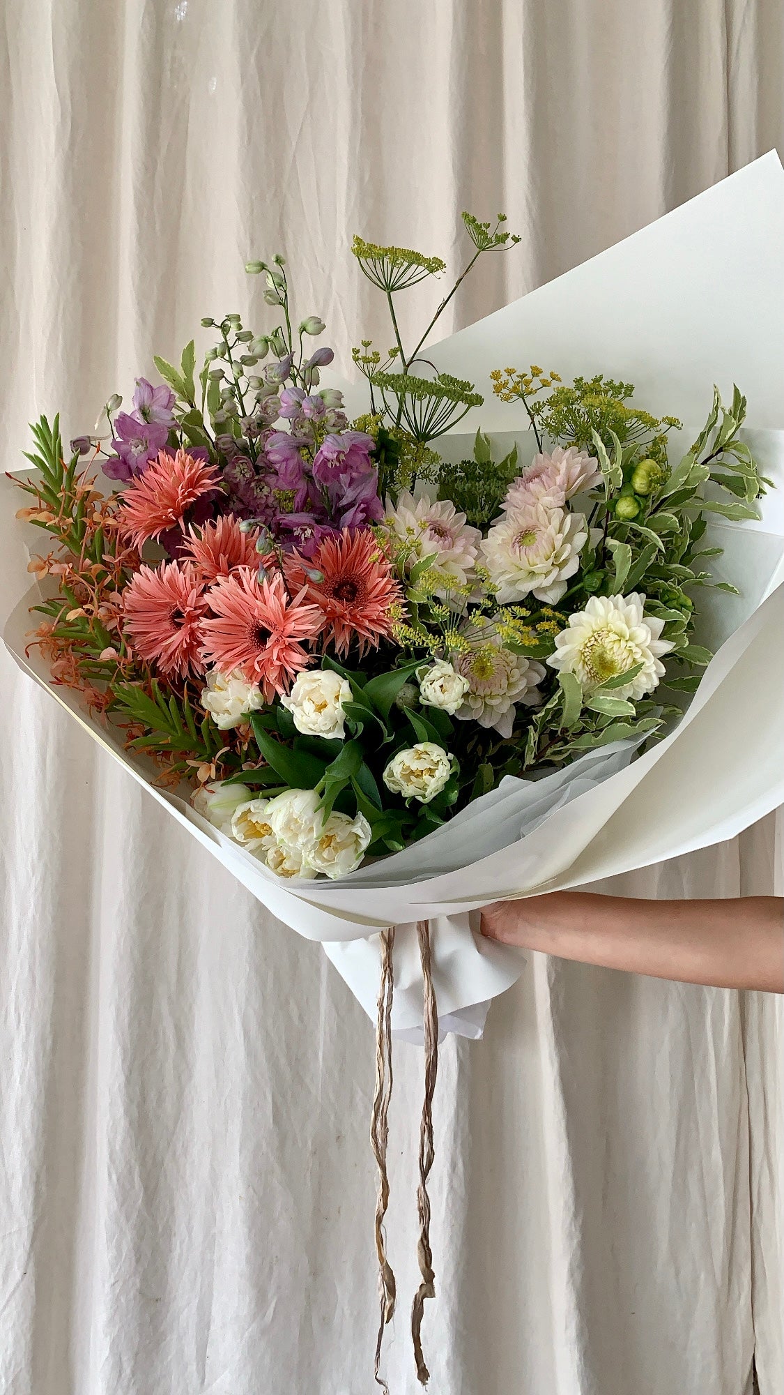 Unique floral arrangement with an unusual mix of flowers and foliage.